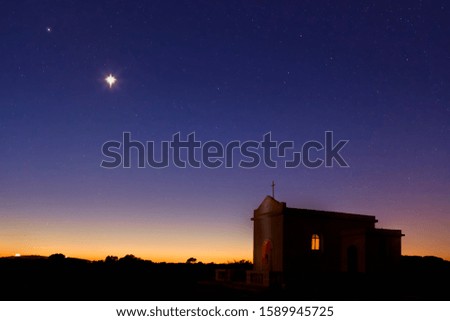 Bright star shining over small chapel