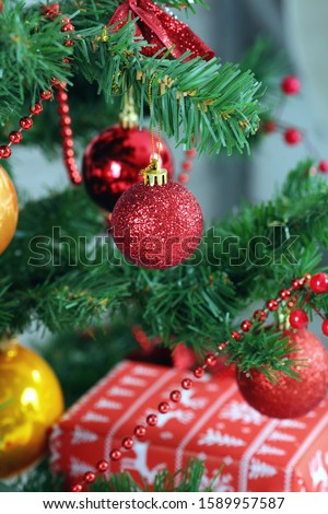 Red Christmas ball on a Christmas tree with a garland