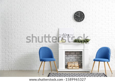 Comfortable blue chairs and fireplace in interior of living room