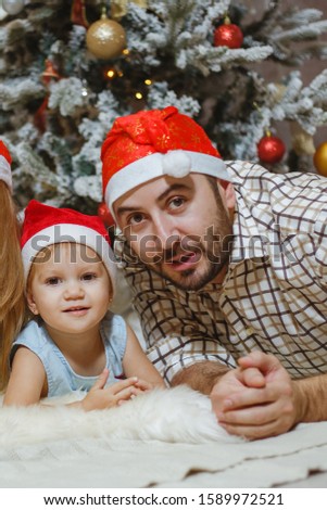 Beautiful family pictures near Christmas tree at home.