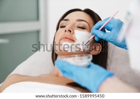 Photo of attractive caucasian woman getting cosmetic procedure by specialist while lying in beauty salon Royalty-Free Stock Photo #1589995450