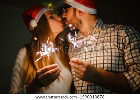 Picture of happy couple with sparklers. On black background