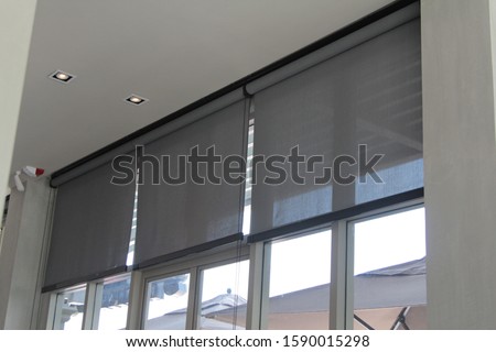 Roller Blinds or curtains at the glass window. Royalty-Free Stock Photo #1590015298