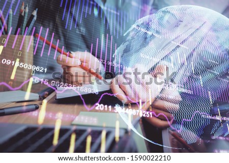 A woman hands writing information about stock market in notepad. Forex chart holograms in front. Concept of research. Multi exposure