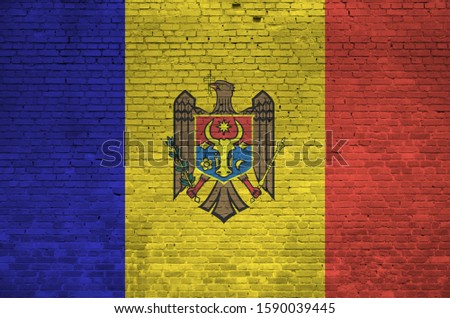 Moldova flag depicted in paint colors on old brick wall. Textured banner on big brick wall masonry background