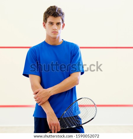 A young man with a squash racket