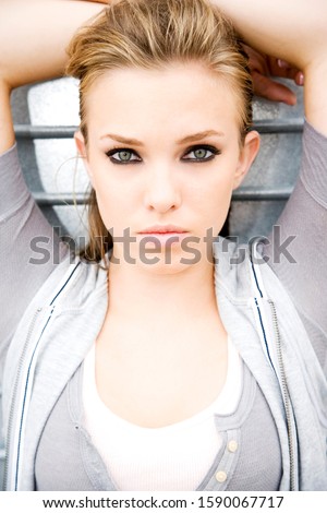Portrait of a young girl leaning against a metallic wall