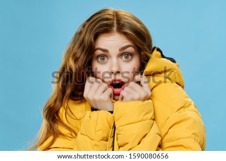 young woman in a beautiful warm jacket yellow isolated background