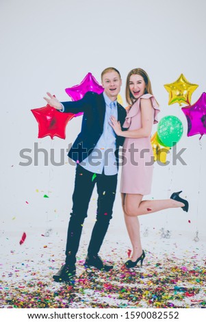 A young woman in the pink dress and a young man in the suit and jeans with merry Christmas, Happy New Year.