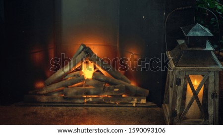 lit lantern with blurred fireplace background in a cozy home interior