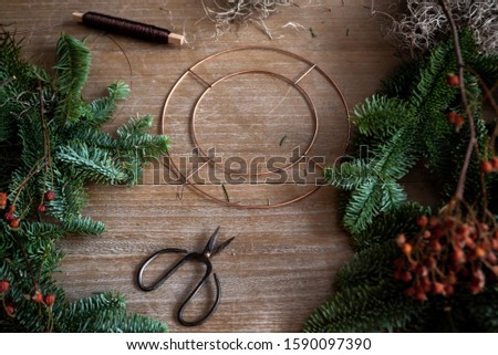 Making Christmas wreath of spruce, step by step. Concept of florist's work before the Christmas holidays.
