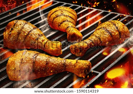 Grilled chicken Legs on the grill with fire and smoke