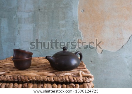 Kettle and cups on a basket.
Delicious tea for health and good infusion.
Against the background of the wall. And standing on the basket. Aesthetics of the East.
Screensaver for the desktop.