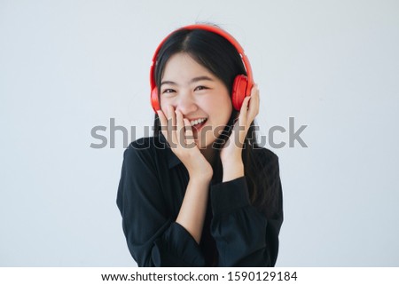 Black long hair girl laugh when she listen the joke from red headphone, white background.