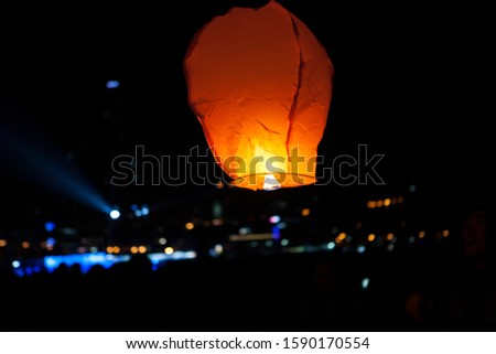 A paper balloon is shining up in the streets of the city of Busan at night.
South Korea