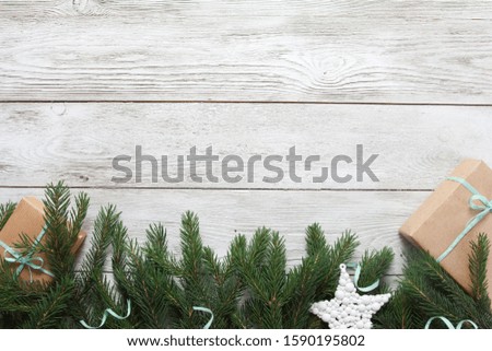 White Christmas baubles, craft gifts, mint streamer, fir tree branches on white wooden table. Christmas background. New Year, winter holiday, copy space, top view