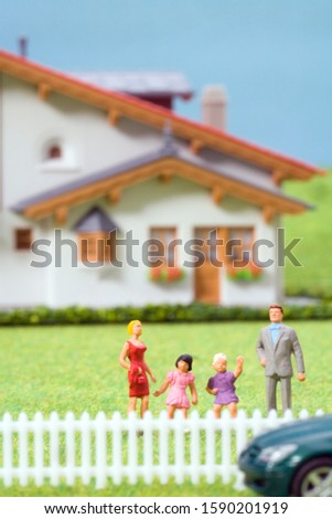 Figurines of family in front of house