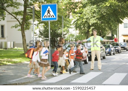 Group of school children crossing street at crosswalk Royalty-Free Stock Photo #1590225457