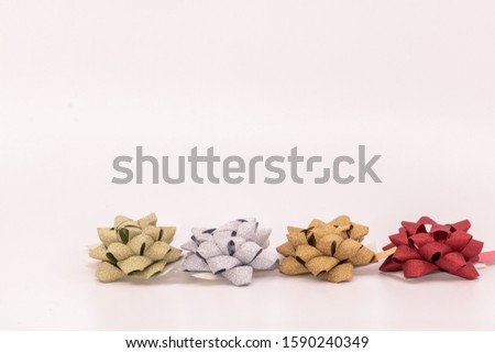 Christmas preparation birthday gifts row of knots gold silver curling ribbon and red on white background with text space