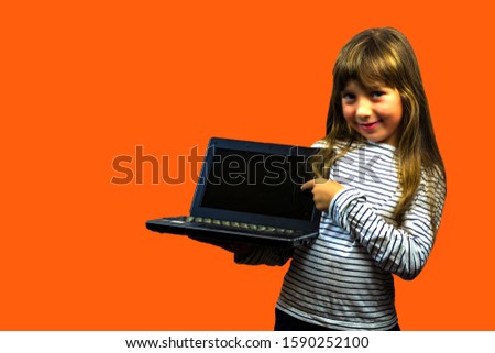 happy little girl with a laptop. school project. start a business. child development in the digital age. play computer games. school education. Art Director. presenting the product.