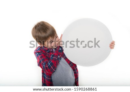 
a boy in stylish clothes holds a round canvas in his hands, a round white tablet Royalty-Free Stock Photo #1590268861