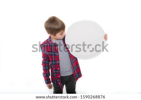 
a boy in stylish clothes holds a round canvas in his hands, a round white tablet Royalty-Free Stock Photo #1590268876