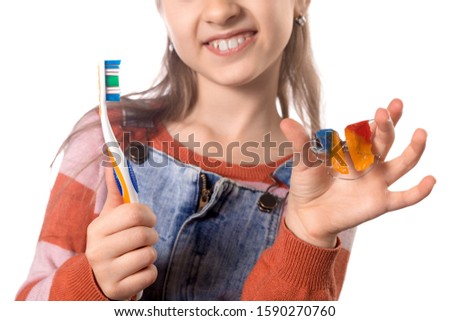 Portrait of a little cute girl with toothbrush and orthodontic appliance on white background. Oral hygiene concept.