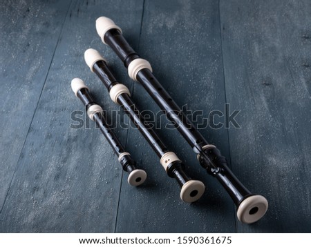 three baroque flutes or recorders isolated on wooden background, music concept Royalty-Free Stock Photo #1590361675