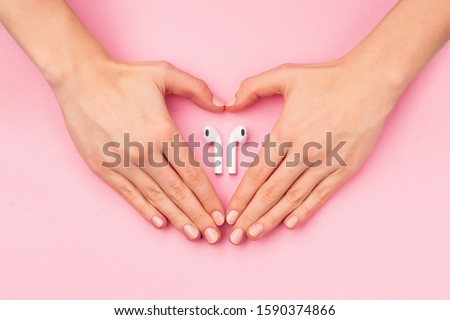 Heart with hands holdind wireless earphones Royalty-Free Stock Photo #1590374866