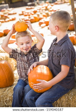 Two Boys at the Pumpkin Patch Talking About Their Pumpkins and Having Fun on a Fall Day. 