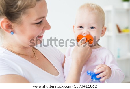 Motherhood, family and children concept - Young mother with her cute little baby at home close-up