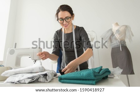 Dressmaker, fashion designer, tailor and people concept - Portrait of a seamstress at work in her own studio