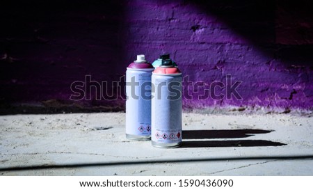 spray paint cans of different colours on the floor