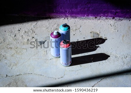 spray paint cans of different colours on the floor
