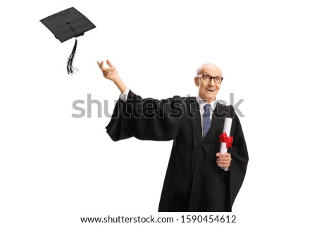 Excited elderly man wearing a graduation gown, throwing hat and holding a diploma isolated on white background