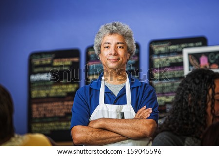 Confident African coffee house owner with folded arms