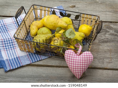 Still life picture of autumn pear harvest in a deco basket and a plaid basket with cute plaid heart on it.