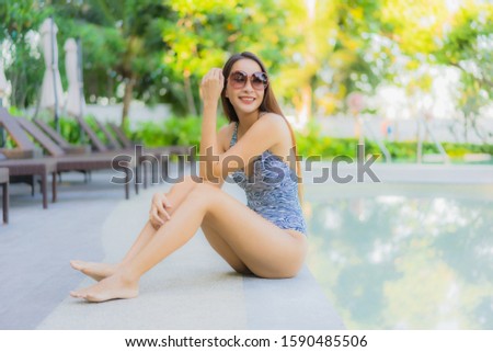 Beautiful young asian women happy smile relax around outdoor swimming pool in hotel resort neary sea beach for travel in holiday vacation