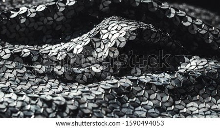 Fabric texture with spangles.  Background sequin. Glitter texture. Fabric sequins. Iron cloth. Silver sequins pattern. Abstract background. Metal structure. Dark thing. Black cloth. 