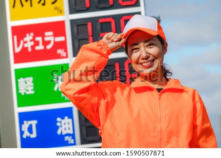 Woman working at a gas station.Translation: "Type of gasoline, regular, light oil, kerosene"