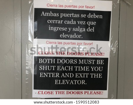 Sign to close elevator doors in English and Spanish