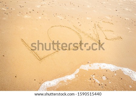Inscription Love on the sand at the beach. Handwriting.