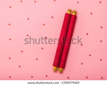 Rolled red flower on pink background with sequins. Holiday message.