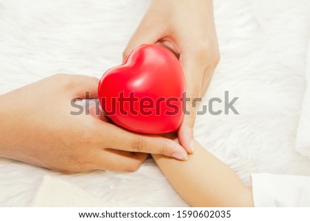 Concept of caring for a baby to be healthy : Closeup hand of a mother who loves babies with a heart