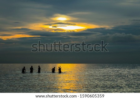 Silhouette. People on the beach with beautiful scenery