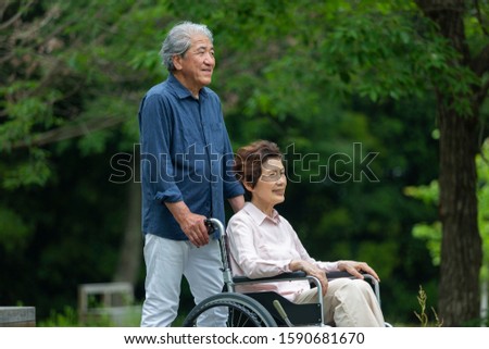 Elderly couple taking a walk in a wheelchair