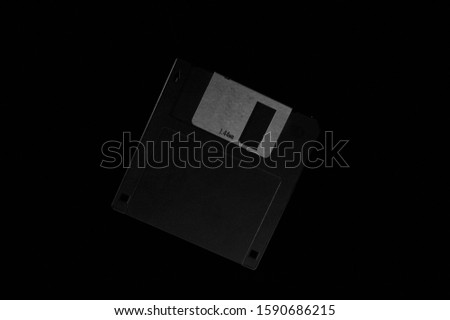 Black and white template of old diskette on dark background.