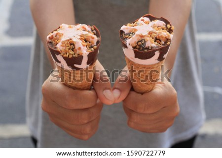 Sharing two ice cream cones.  Hands holding ice cream cones. Giving is caring. Lovely pictures.