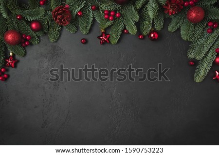 Christmas winter arch with fir branches, red balls on natural black background. Xmas greeting card. Holiday time. Happy New Year. Space for text. View from above, flat lay.