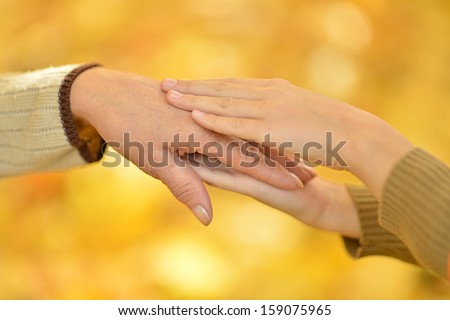 hands against the fallen yellow leaves